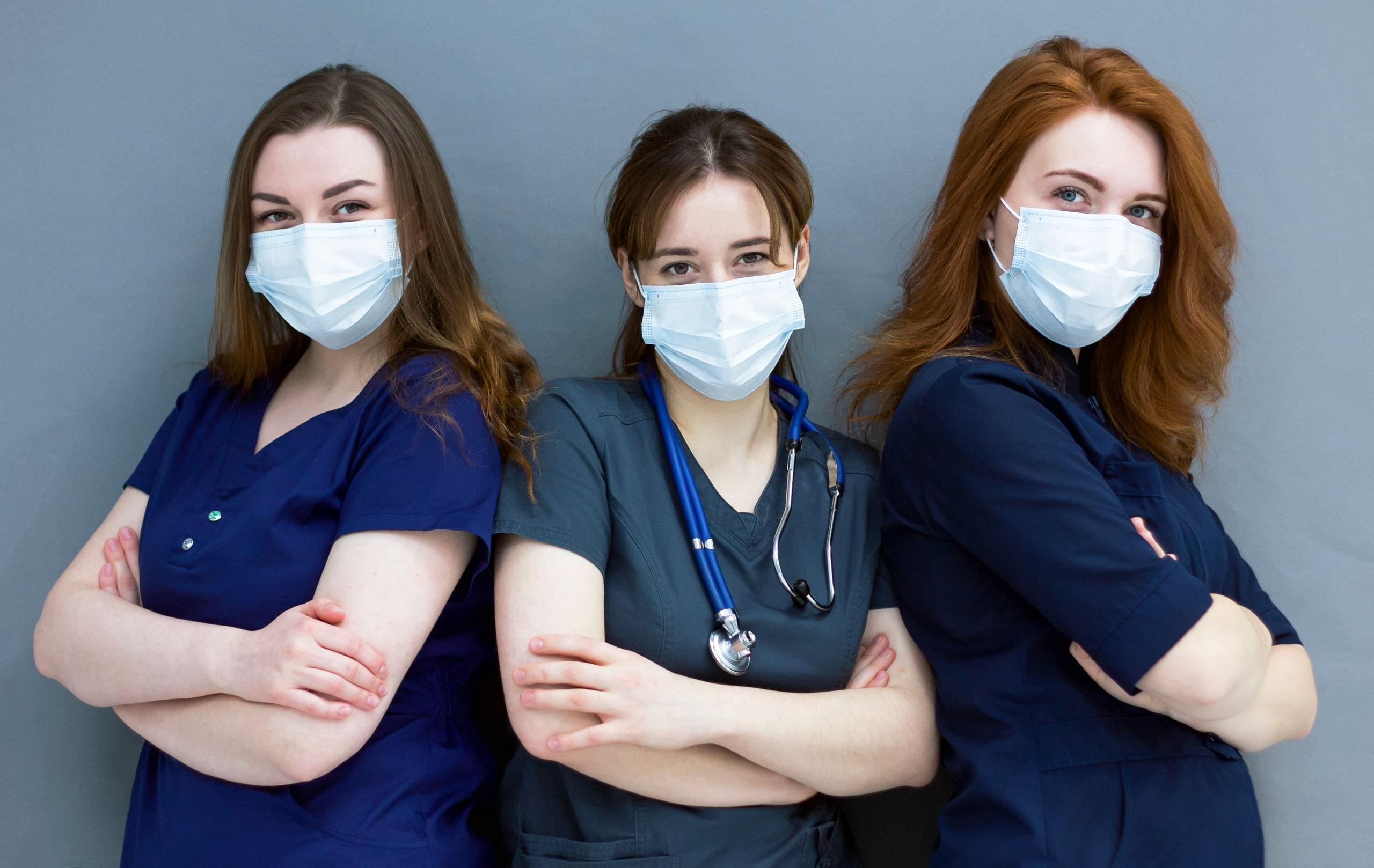 Trio of young masked nurses